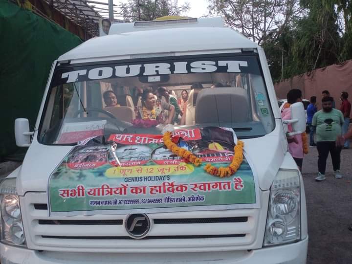 Woman holding digital camera and looking away with mixed race man holding map near travel bus